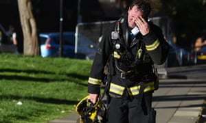 برج مسکونی لندن در حال فرو ریختن است 11 پایگاه خبری ججین A firefighter reacts after battling a huge blaze at the Grenfell Tower.
