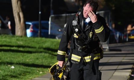 A firefighter reacts after battling the huge fire at the Grenfell Tower.