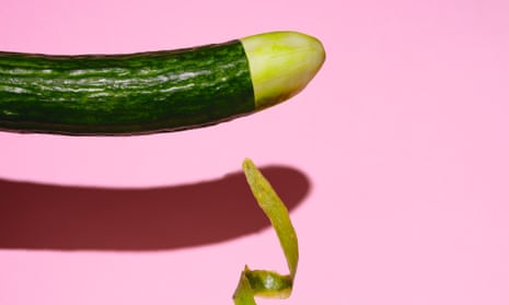 Photograph of a cucumber with the tip peeled and a piece of peel falling down