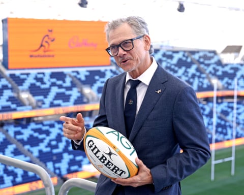 Les Kiss sostiene un balón con las gradas y las porterías del estadio al fondo.