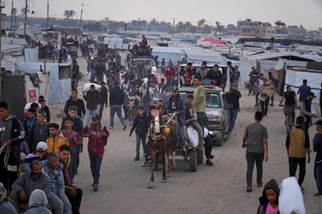 Palestinians carry bags filled with food and humanitarian aid in Khan Younis.