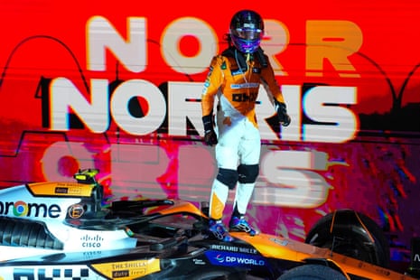 Lando Norris of McLaren stands on his car as he celebrates after winning the Singapore Formula 1 Grand Prix