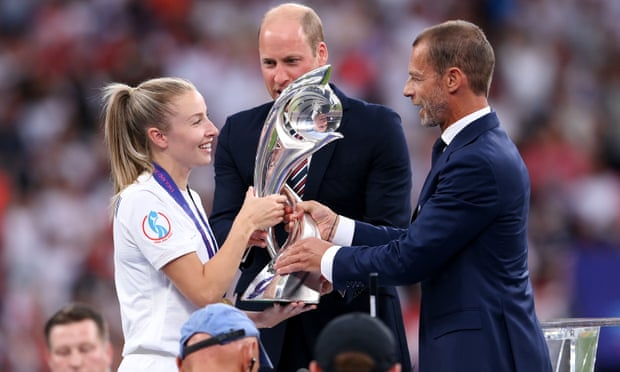 Leah Williamson is given the Euro 2022 trophy by the president of Uefa.