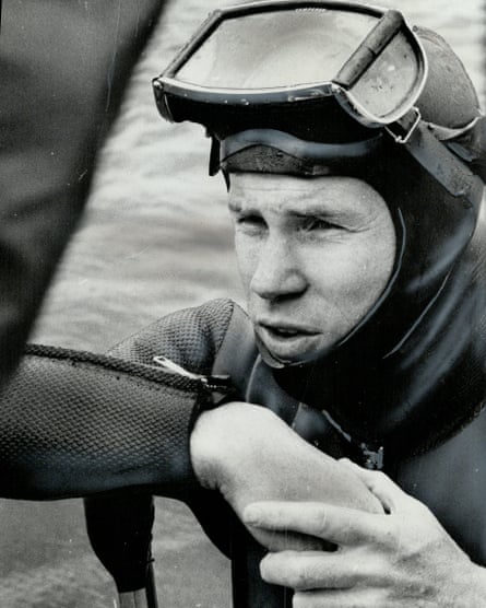 A black and white photo of a man in a diving suit