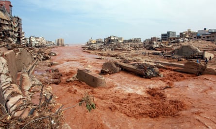 People look at the damage caused by floods in Derna