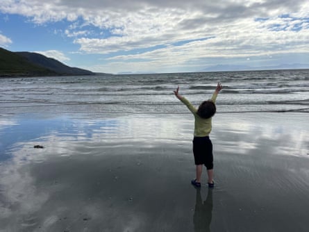 Young boy on the beach with arms outstretched