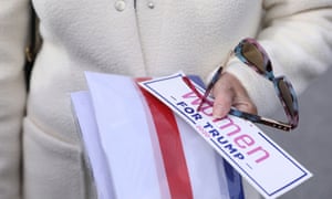 A woman holds a sticker before joining a car caravan supporting Donald Trump in Easton, Pennsylvania. Trump appears to have been losing ground among white women.