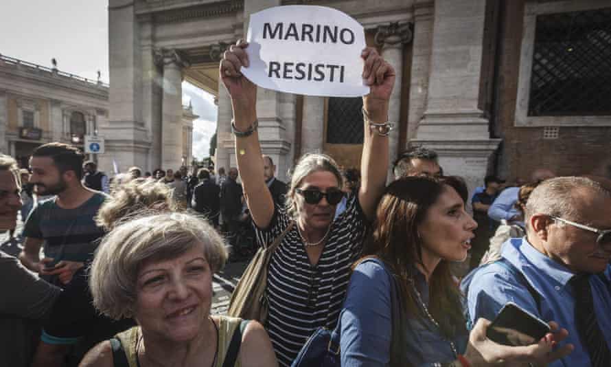 A pro-Marino demonstrator holds a placard reading ‘Marino resist’ during a rally outside Rome’s city hall.