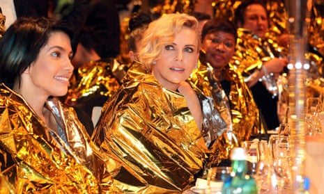 The actor Charlize Theron sits wrapped in an emergency blanket alongside Nadya Tolokonnikova at the Cinema for Peace event.