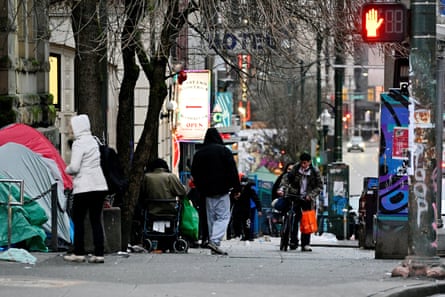 People loitering on a city street next to tents