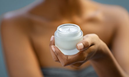 woman holding jar of face cream