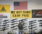 A salesperson reaches up to take an AR-15 rifle off a gun store wall in Orem, Utah