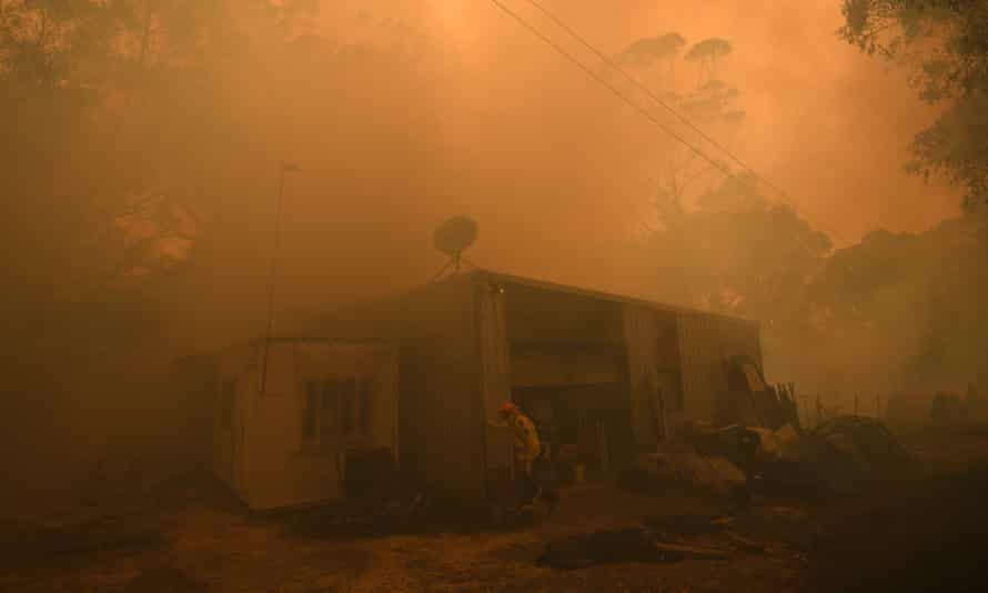 Firefighters work to protect a property in Kulnura as the Three Mile fire approaches Mangrove Mountain in NSW on Friday.