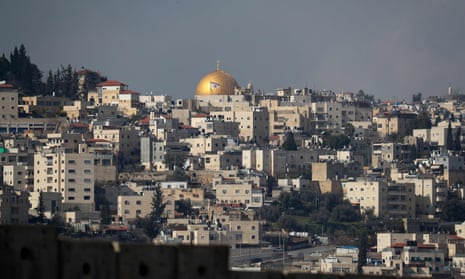 An Israeli flag flutters in front of the Dome of the Rock, seen from the Palestinian village of Abu Dis.