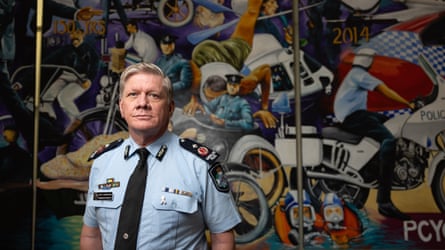 Cameron Harsley in front of a police mural