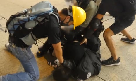 Undercover police officers, disguised as protesters, arresting a man outside SOGO department store in Causeway Bay, Hong Kong