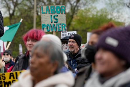 a person holds a sign that reads ‘labor is power’