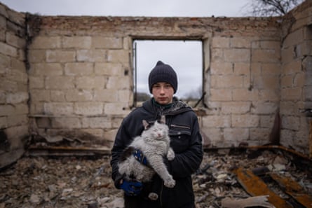Danyk Rak, 12, holds a cat standing on the debris of his house destroyed by Russian shelling in the village of Novoselivka, near Chernihiv, 13 April.
