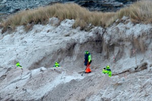 Zimbabweans work on a mined beach in Stanley