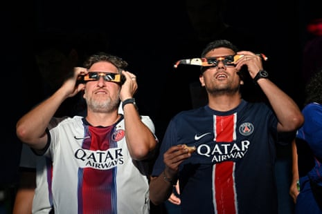 The PSG fans watch the solar eclipse inside the stadium before kick-off.