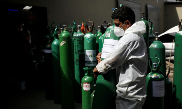 A volunteer carries an empty oxygen cylinder in Manus, Brazil