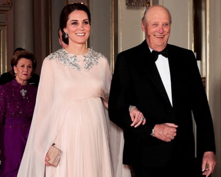 Princess Catherine in a flowing Alexander McQueen gown walking arm in arm with King Harald, wearing a tuxedo