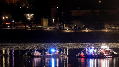 Emergency personnel and divers work next to parts of the wreckage of the American Eagle flight 5342 in the Potomac River.