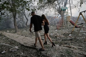 Couple walking amid debris from bombed buildings in Kramatorsk