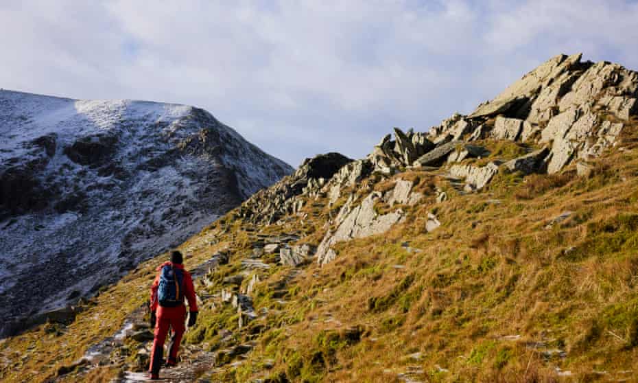 A fell assessor climbs Helvellyn in the Lake District