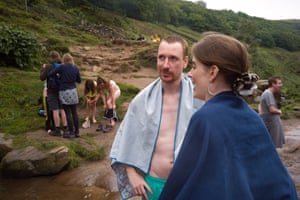 Holidaymakers swim on an overcast day at Three Shires Head in the Peak District.