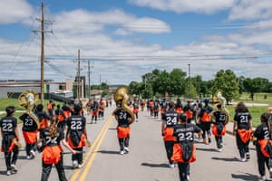 A band marches through residential streets in the Greenwood district during commemorations