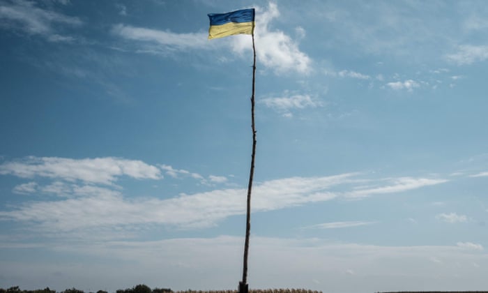 The Ukrainian national flag is seen at the entrance of the village in Troitske, Kharkiv region.