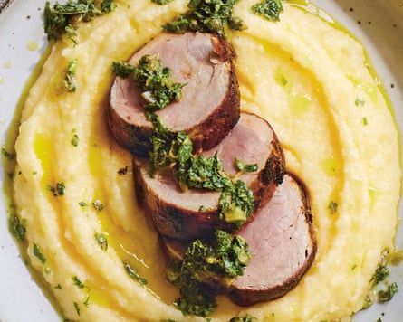 A picture, taken from above, of some soft polenta topped with three slices of pork fillet and drizzled with salsa verde.
