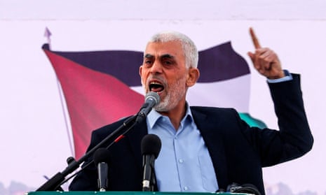 Yahya Sinwar speaks at a lectern holding one finger up.