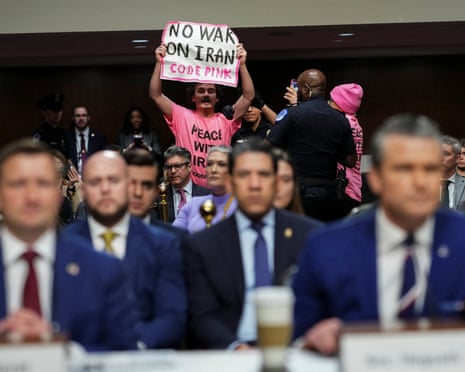 The protester, holding a banner saying ‘no war on Iran’, was removed by security.