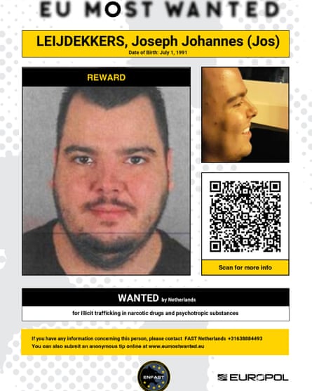 A Europol wanted poster feature a white man with dark facial hair