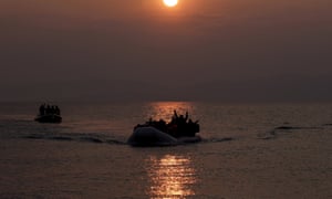 Refugees and migrants wave as they approach Lesbos in March 2016.