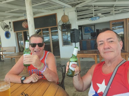 Paul Longworth (left) and Albert Alfonso holding bottles of beer at an outdoor dining table