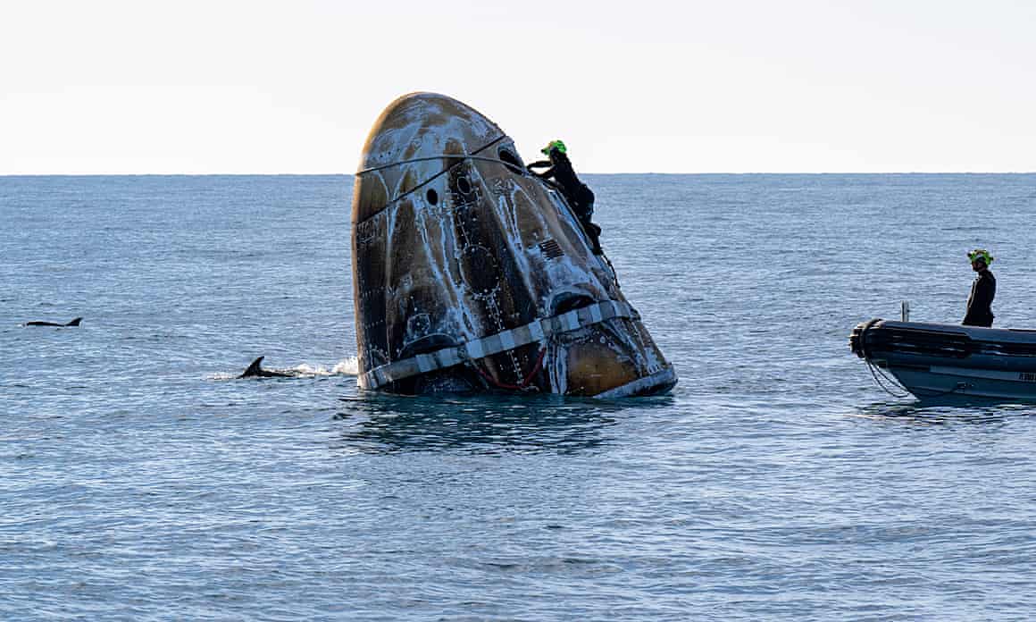 Support worker around the SpaceX capsule after its landing in water