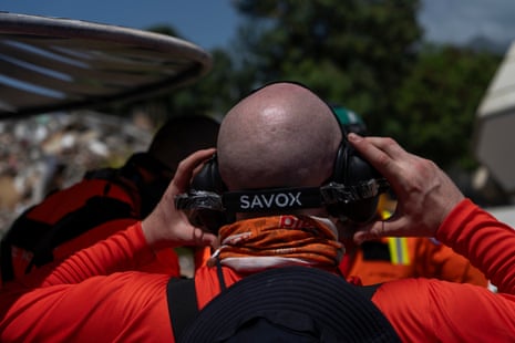 A member of the UK team uses headphones linked to a listening device to try to locate buried survivors.