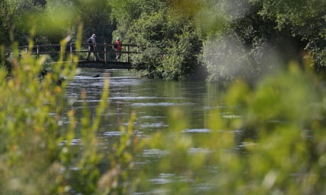 People cross a bridge over the River Itchen in Hampshire People cross a bridge over the River Itchen in Hampshire