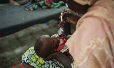 A woman feeds a young baby suffering from severe malnutrition at the therapeutic feeding centre in the Gwangwe district of Maiduguri, in north-east Nigeria