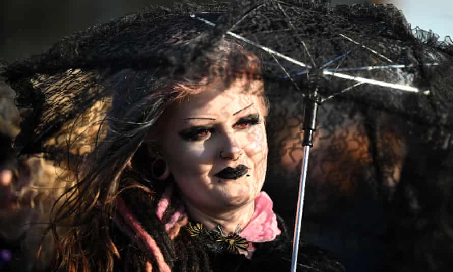 Woman with red contact lenses and black lipstick and eye makeup.