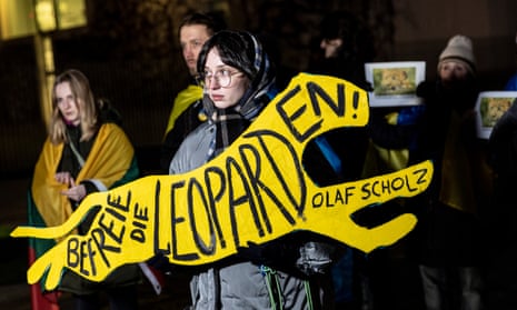 A protester holds a sign saying: ‘Free the leopards Olaf Scholz’ at a demonstration in Germany.