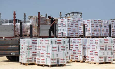 Lorry next to lots of pallets of boxes