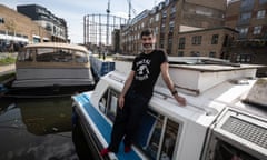 Man standing on side of his canal boat wearing socks.