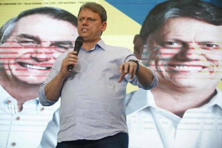 Tarcísio de Freitas speaks during a press conference in Sao Paulo, Brazil, on 17 October in front of a poster featuring the country’s far-right president, Jair Bolsonaro.