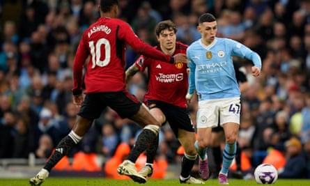 Manchester City’s Phil Foden, right, controls the ball the ball as Manchester United’s Marcus Rashford, left and Victor Lindelöf challenge