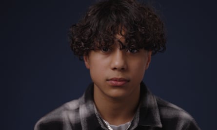 Leon Ung, with a curly fringe and in a collared plaid shirt, looking serious