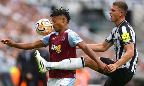 Ole Watkins of Aston Villa plays with Sven Putman of Newcastle United.